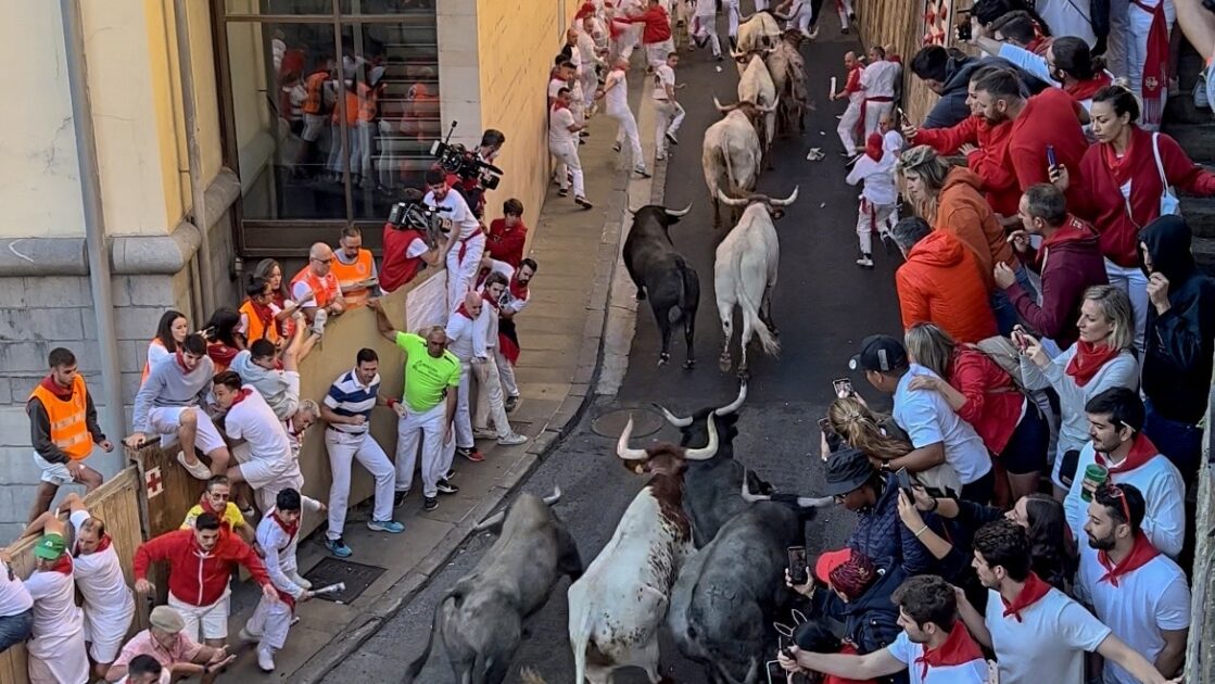 パンプローナの狭い石畳を駆け抜ける闘牛と、逃げるランナーたちの緊迫したエンシエロ（牛追い）の様子