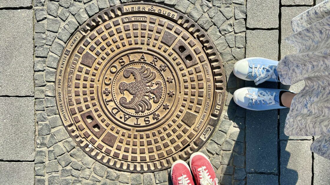 ドイツのハルツ地方にある世界遺産の街ゴスラーの紋章入りのマンホールと靴