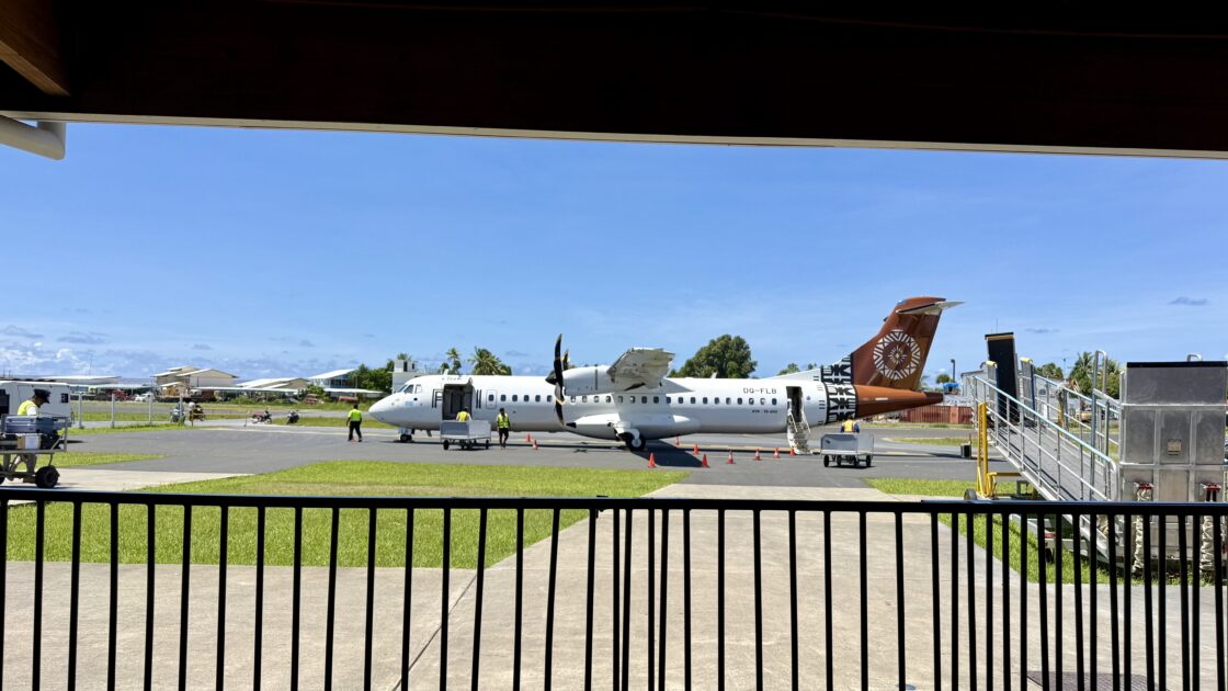 ツバルの入国審査待ちの列から見た美しい青空とフィジー・エアウェイズのプロペラ機