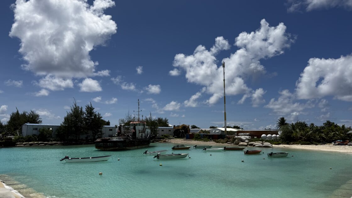 ツバルの青い海と晴天の下、カラフルな小舟が並ぶボートツアー出発の港