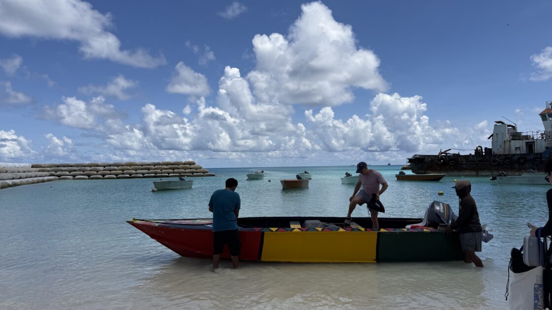 ツバルのポートで、美しい海に浮かぶカラフルなボートに乗り込む前の様子。
