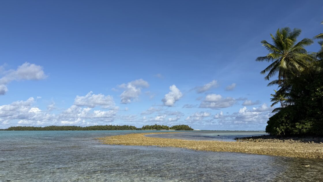 ツバルのアバラウ島（Avalau）にある、海の中に伸びる砂利の道と青空