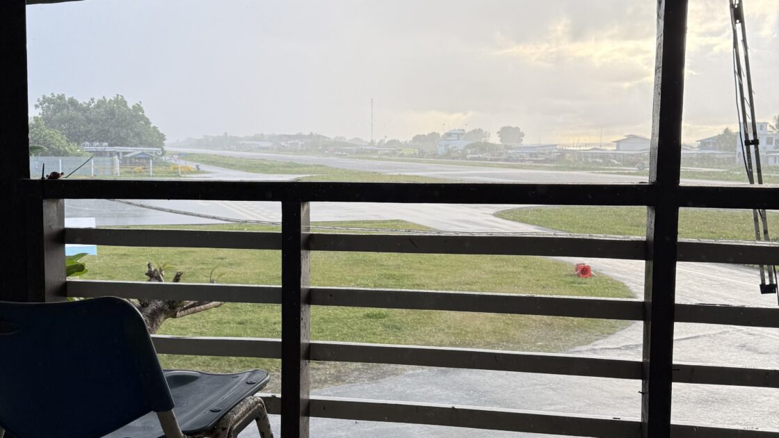 ツバルのフィラモナロッジVIPルームのベランダの椅子と、そこから見える雨に濡れた滑走路。