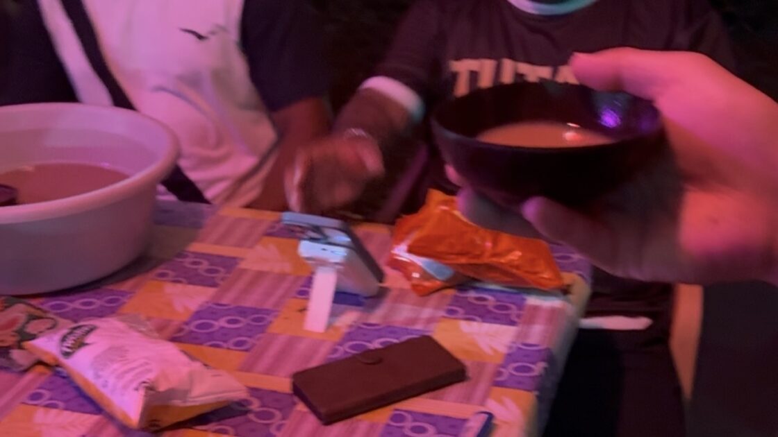 ココナッツの殻の器に入った伝統飲料カヴァを手渡されている様子。