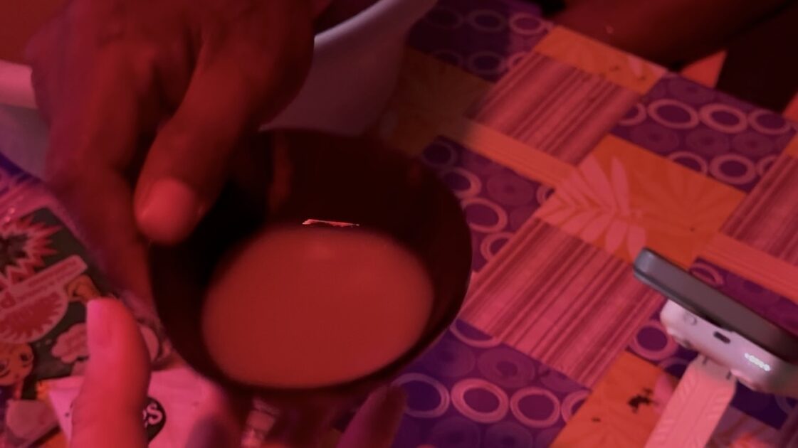 現地の人からカヴァの入ったココナッツの器を差し出されている瞬間の写真。